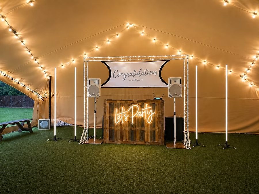 DJ Prestige rustic wooden booth with illuminated Let's Party sign