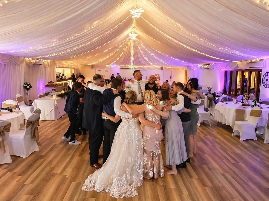 Wedding party embracing together at the end of the night